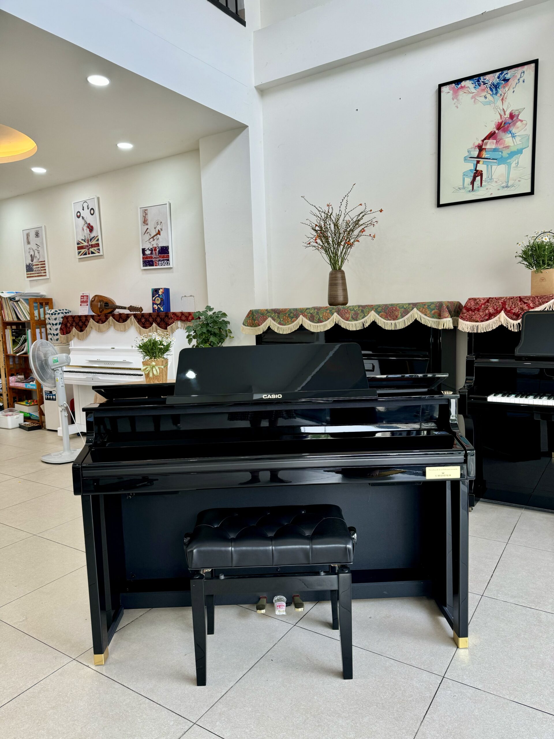 Đàn piano điện Casio GP-1000 PE với thiết kế gương đen bóng, kiểu dáng sang trọng và ghế ngồi da chần nút