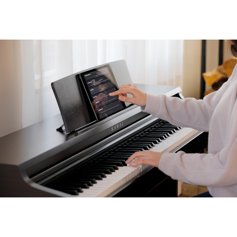 Người dùng điều chỉnh ứng dụng trên máy tính bảng kết nối đàn piano điện Kawai KDP-120 qua Bluetooth MIDI
