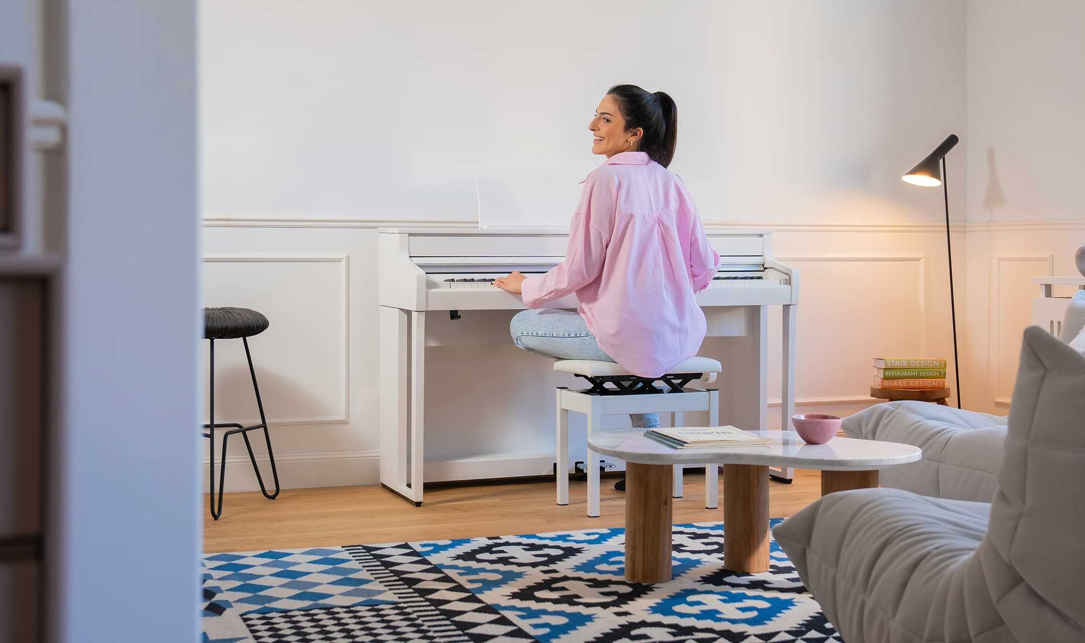 hình ảnh người phụ nữ đang chơi đàn piano kawai ca501 màu trắng trong căn phòng cùng tông màu nền nã