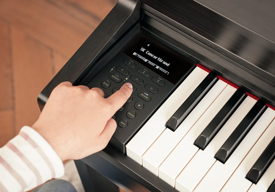 Tìm hiểu thêm các tính năng của Kawai CN 301 B hình ảnh bàn tay người chơi đang nhấn vào nút chức năng trên bảng điều khiển kawai cn 301 b